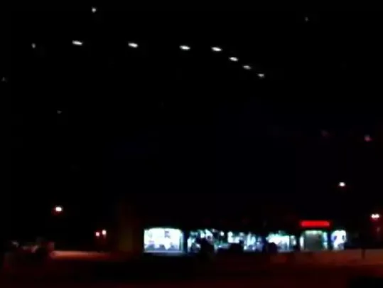 Luzes triangulares brilhantes no céu noturno sobre a cidade de Phoenix.